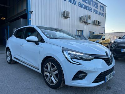une voiture blanche garée devant un immeuble, à côté d'autres voitures