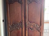 a large wooden armoire in the corner of a room