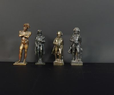 trois figurines en bronze représentant un homme et une femme, posées sur un fond noir