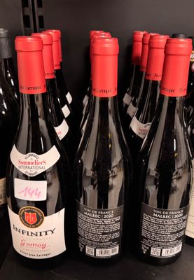 several bottles of wine are lined up on a shelf in a store