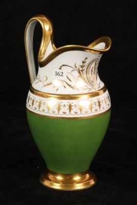 a green and white vase with a gold handle on a black background