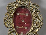 une photo d'une broche rouge et dorée posée sur une table
