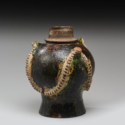 une image représentant un vase noir avec un serpent sur l'anse