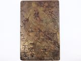 une vieille plaque métallique sur laquelle figurent une femme et un homme