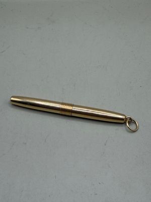 a gold colored metal pen with a keychain on a table