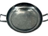 a metal pan with a handle on a white surface