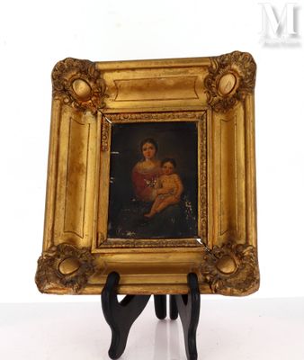 painting of a woman holding a child in a gold frame on a stand