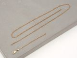 a close up of a gold chain on a gray surface