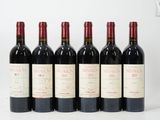 six bouteilles de vin rouge alignées sur une surface blanche