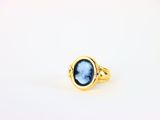 une bague en or avec une pierre bleue au centre