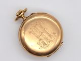 a gold pocket watch on a white surface