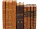 plusieurs vieux livres sont alignés sur une surface blanche