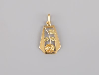 a close up of a gold plated pendant on a gray surface