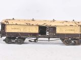 trois wagons miniatures sont alignés les uns à côté des autres sur une surface blanche