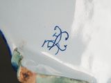 a close up of a blue and white plate with a bicycle on it