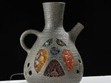 a gray vase with a multicolored design on it