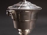 an antique silver plated sugar bowl with a lid on a black background