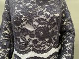 a woman that is wearing a black and white lace top