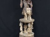 a wooden statue of a man holding a knife on top of a table