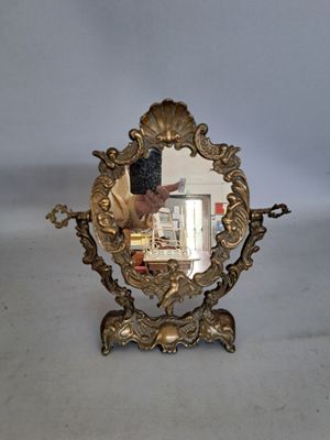 un miroir posé sur une table, devant lequel une personne prend une photo