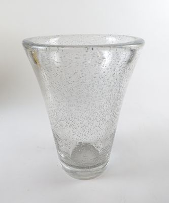 le petit vase en verre est posé sur une surface blanche