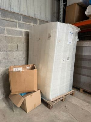 deux cartons de matelas posés sur une palette dans un entrepôt
