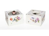 two small white boxes with flowers on them on a white surface