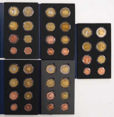 six different types of coins are displayed in a display case