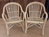 pair of white wicker chairs in front of a wooden door