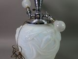 a white vase with a light on top of it
