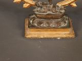 bronze statue of a man holding a fish on a wooden base