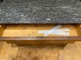 a wooden table with a marble top on a hard wood floor