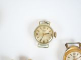 three different types of watches displayed on a white surface