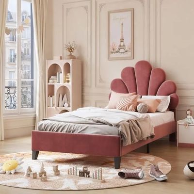 a bed with a pink headboard in the middle of a room