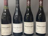 quatre bouteilles de vin sont alignées sur une table