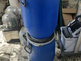 a blue trash can sitting on the floor next to a vacuum