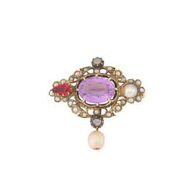 un gros plan sur une broche ornée de perles et de pierres précieuses