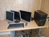 three computer monitors and a keyboard on a desk