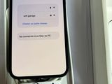un iPhone avec un bouton Wi-Fi à l'écran, posé dans une boîte