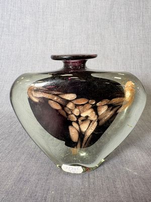 un vase en verre dans lequel se trouve l'image d'une femme en robe