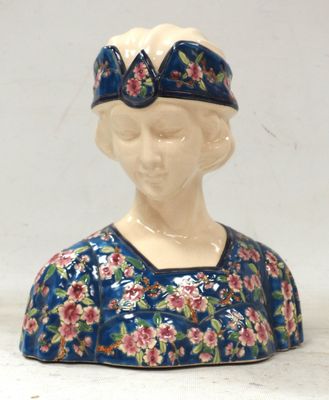 une figurine en céramique représentant une femme vêtue d'une robe bleue