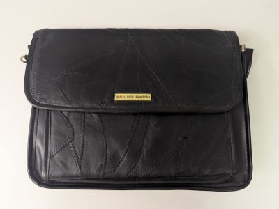 un sac à main en cuir noir orné d'une boucle dorée sur le devant