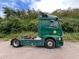 a green semi truck parked in a parking lot