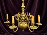 un lustre en laiton à cinq bougies sur fond violet