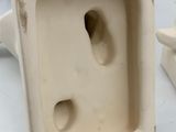 a white vase with a hole in it on a table