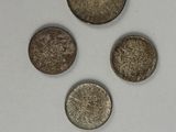four different types of coins are shown on a white surface