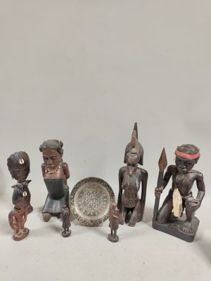 un groupe de figurines en bois assises les unes à côté des autres sur une table