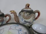 a tea pot and two cups sitting on a table