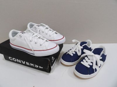 une paire de Converse blanches et bleues posées sur une boîte