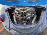 a small blue car with an engine in it ' s trunk